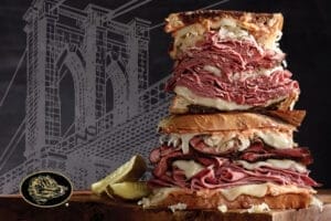 John Arena standing in a classic New York setting, relevant to Arena Provisions careers Jacksonville, with urban backdrop.